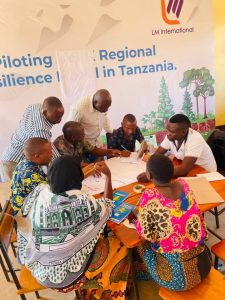 Community leaders and members discussing the allocation of resources in their villages to create climate resilience community action plan in Ng’hambi ward.